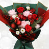 Bouquet of red and pink flowers wrapped in green paper