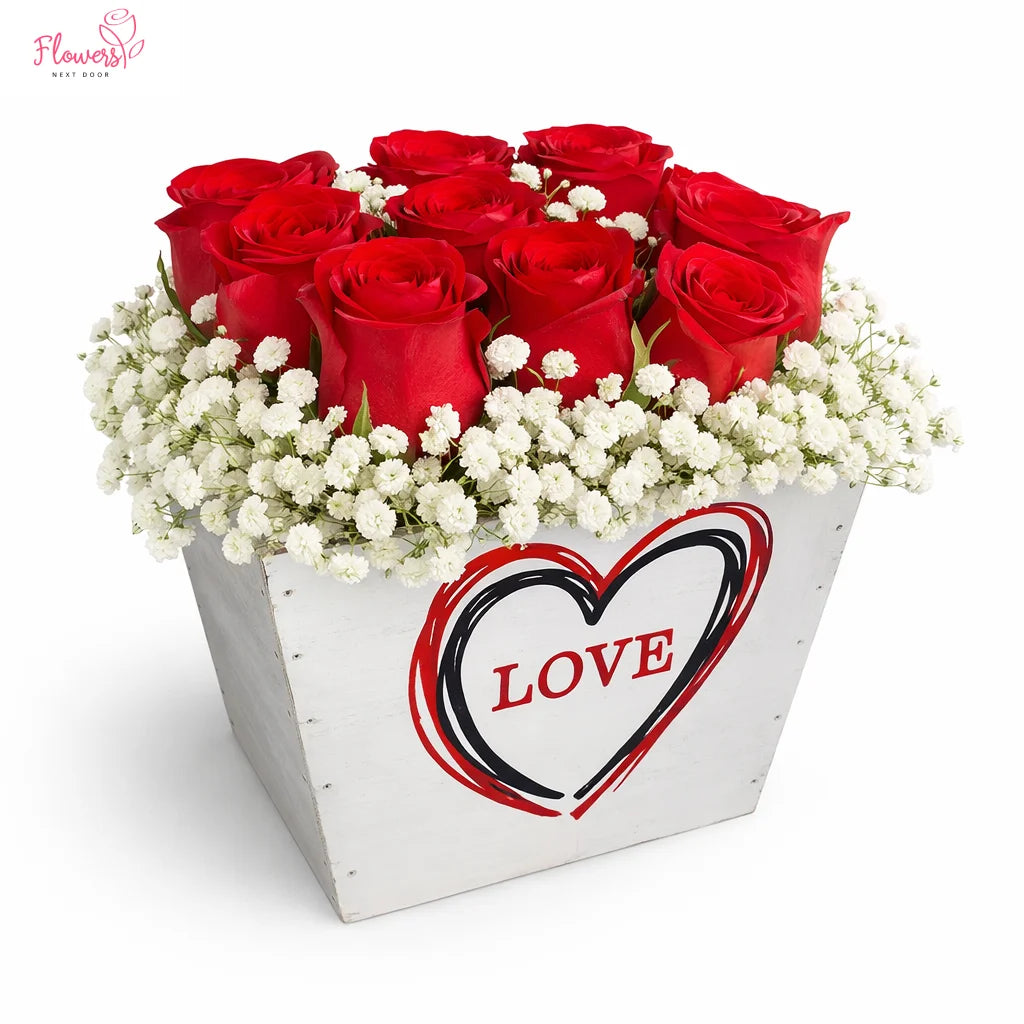 Bouquet of red roses with white baby's breath in a box with 'LOVE' heart design on a white background