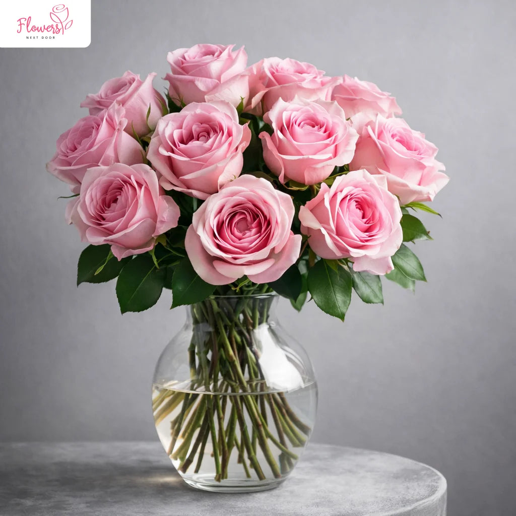 Bouquet of pink roses in a clear vase on a gray background